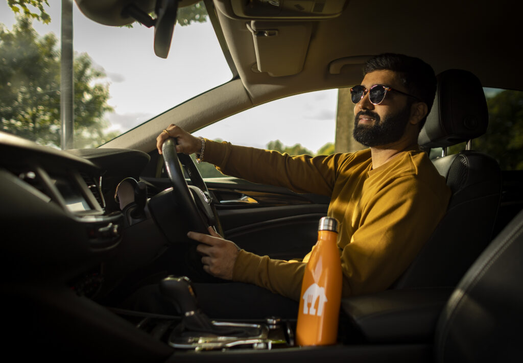 A Just Eat courier driving a car in summer