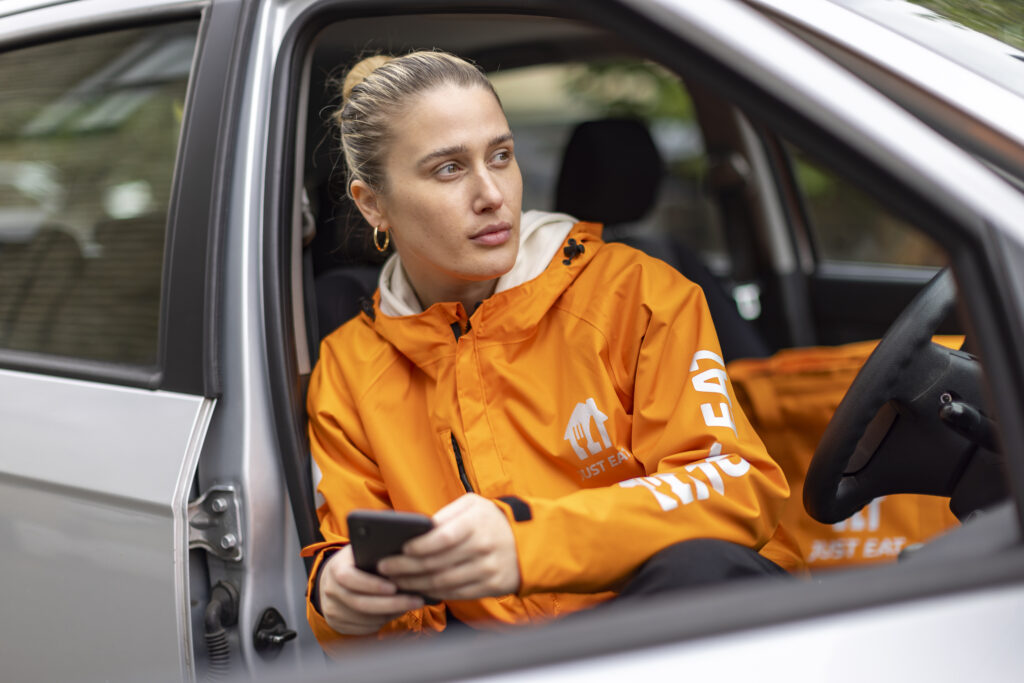 A Just Eat courier in a car