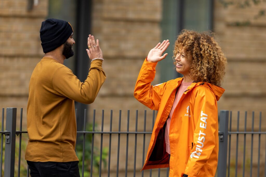 Just Eat couriers high fiving each other