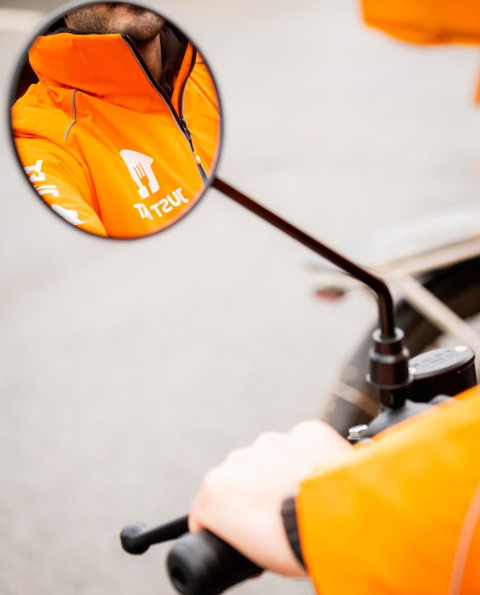 A Just Eat courier on an orange ebike
