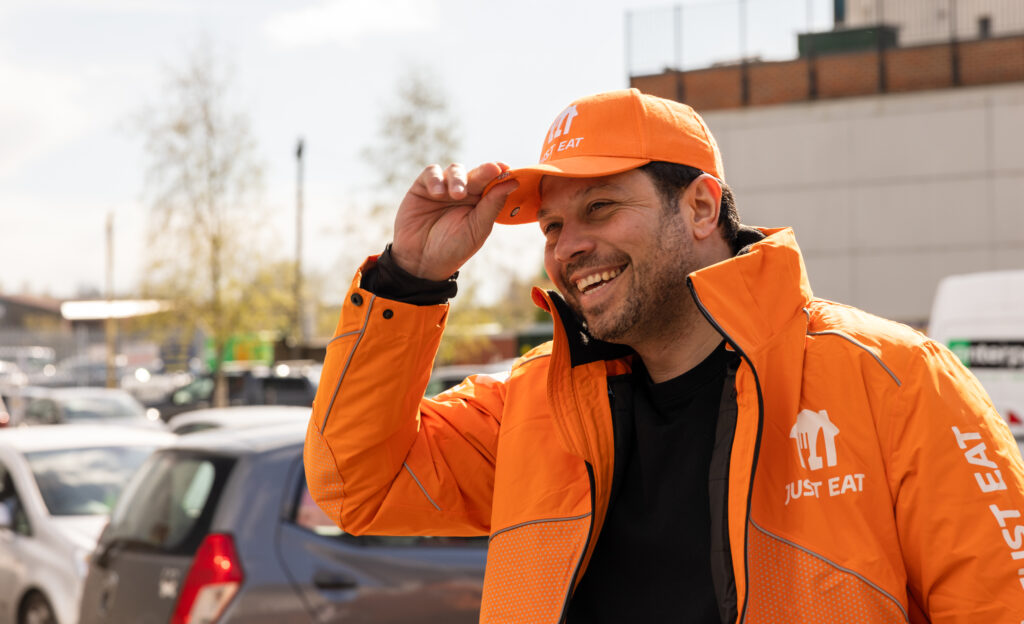 A picture of a Just Eat courier tipping his hat