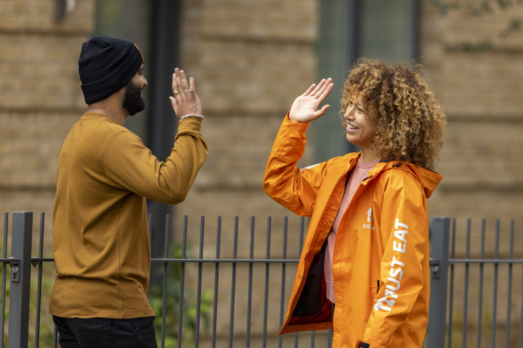 A Just Eat UK Courier high fiving a colleague